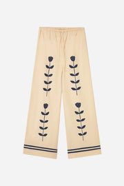 Beige pants with black floral patterns on a white background