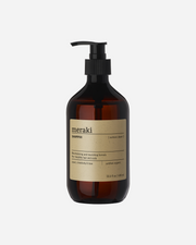 A bottle of Meraki Northern Dawn Shampoo with a pump dispenser, labeled with the product information.
