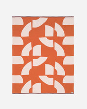 Orange blanket with white geometric pattern on a white background