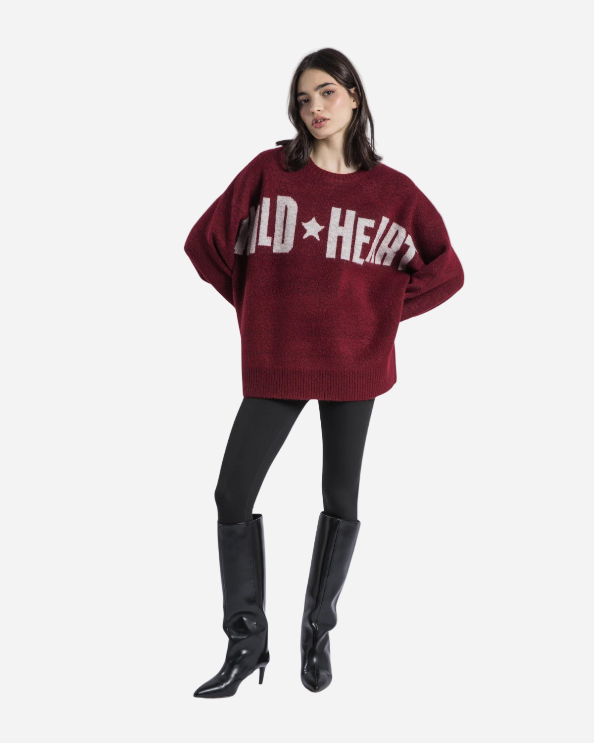 Person wearing a maroon sweater with 'Wild Heart' text, black pants, and black boots on a white background