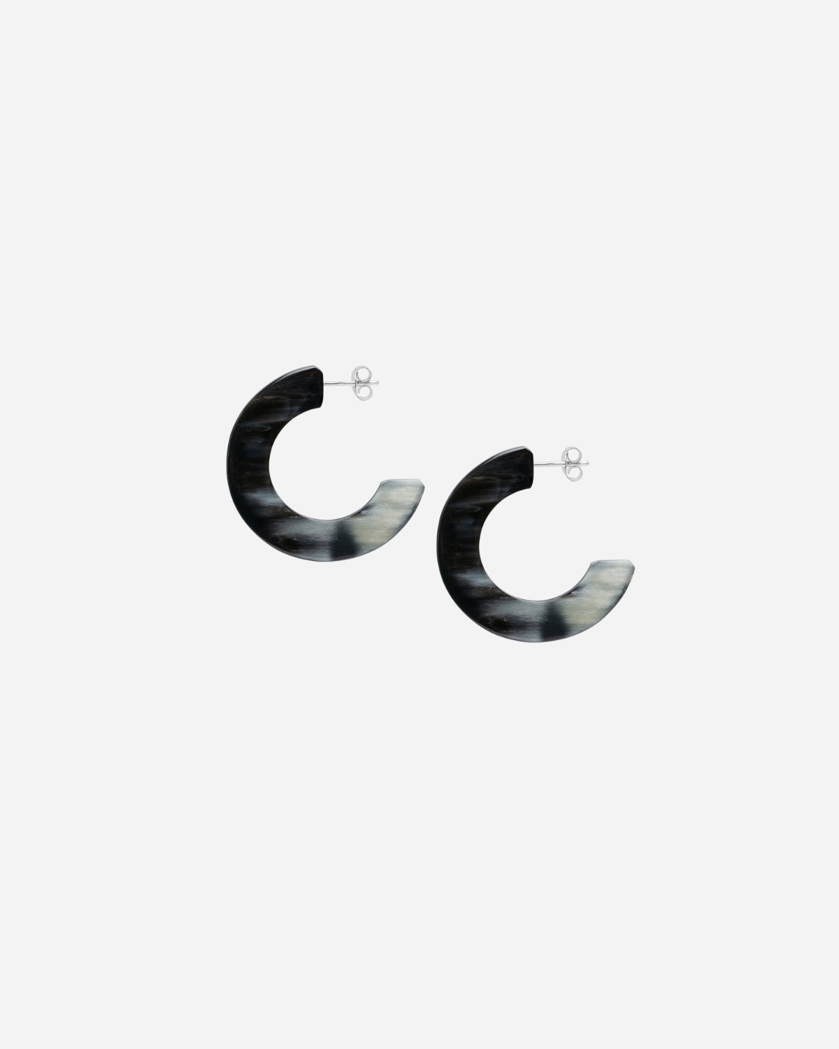 Pair of black and white hoop earrings on a light gray background