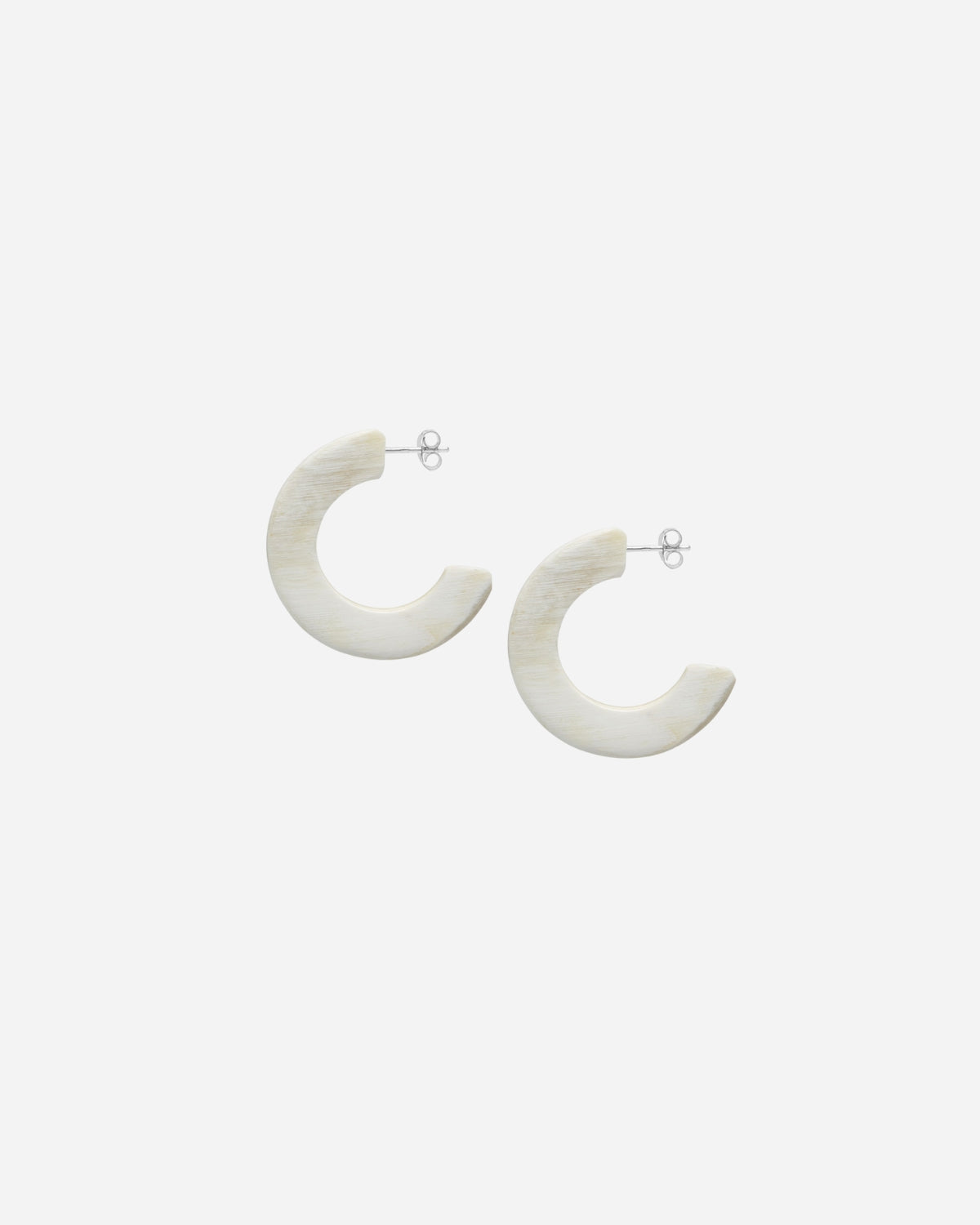Pair of natural white hoop earrings on a white background