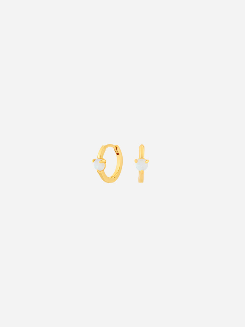 Gold hoop earrings with small round stones on a white background