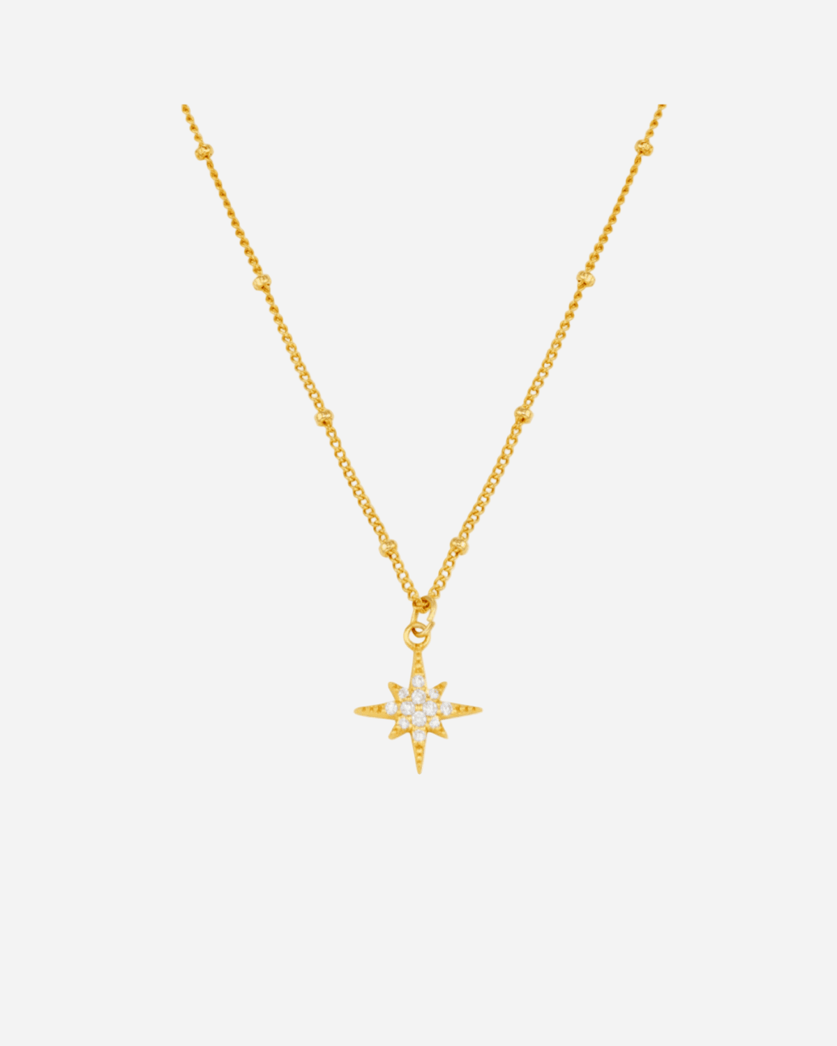 Gold necklace with a star-shaped pendant on a white background