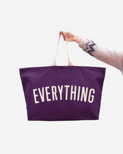 Dark purple canvas tote with white handles and EVERYTHING printed in white