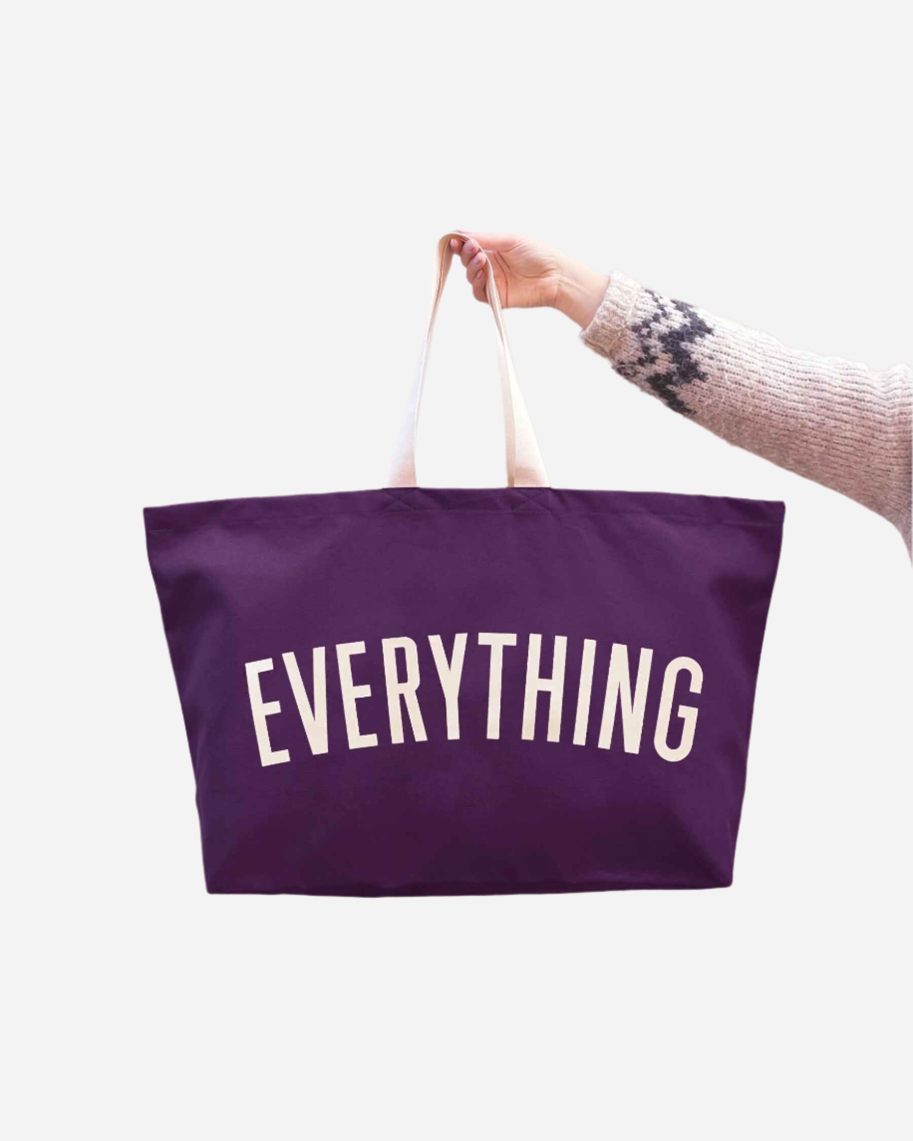 Dark purple canvas tote with white handles and EVERYTHING printed in white